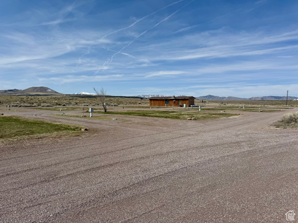 View of dirt / gravel road featuring a mountain view and a view of countryside
