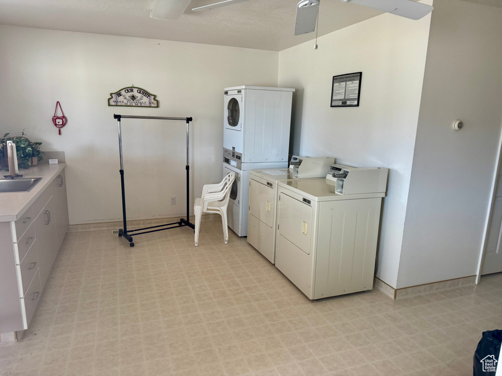 Laundry room with stacked washing machine and dryer and light flooring