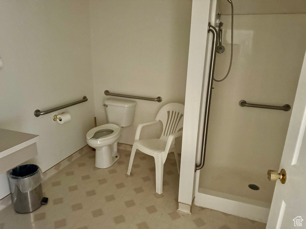 Bathroom with a shower stall and tile patterned floors
