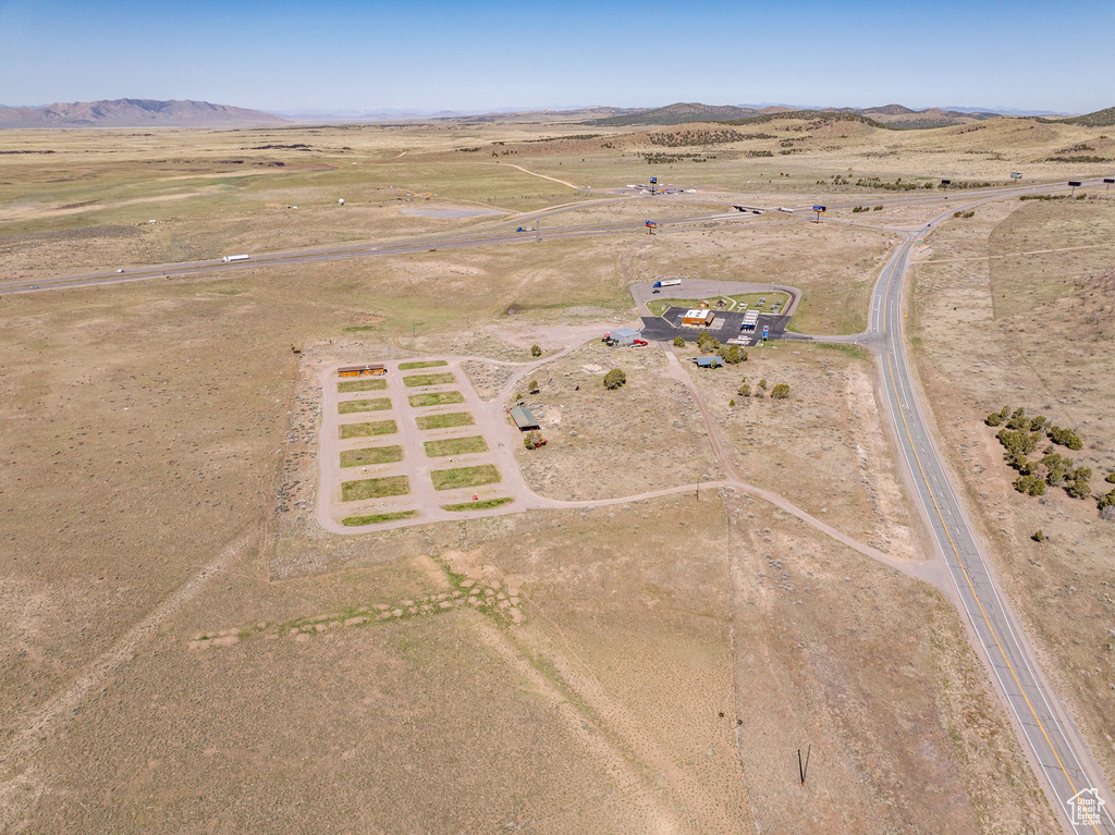 Aerial view of property and surrounding area featuring rural landscape and a mountainous background