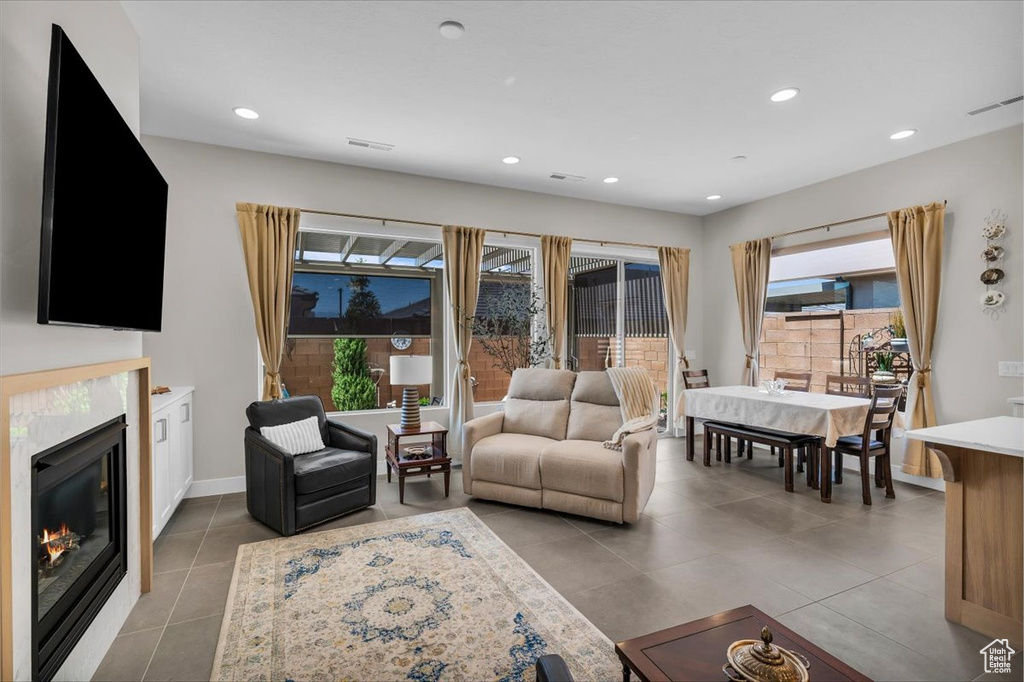 Living area with tile patterned flooring, recessed lighting, and a glass covered fireplace