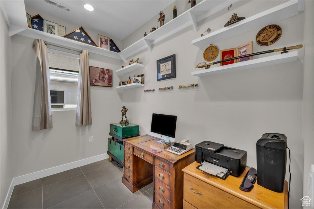 Office with baseboards and dark tile patterned flooring