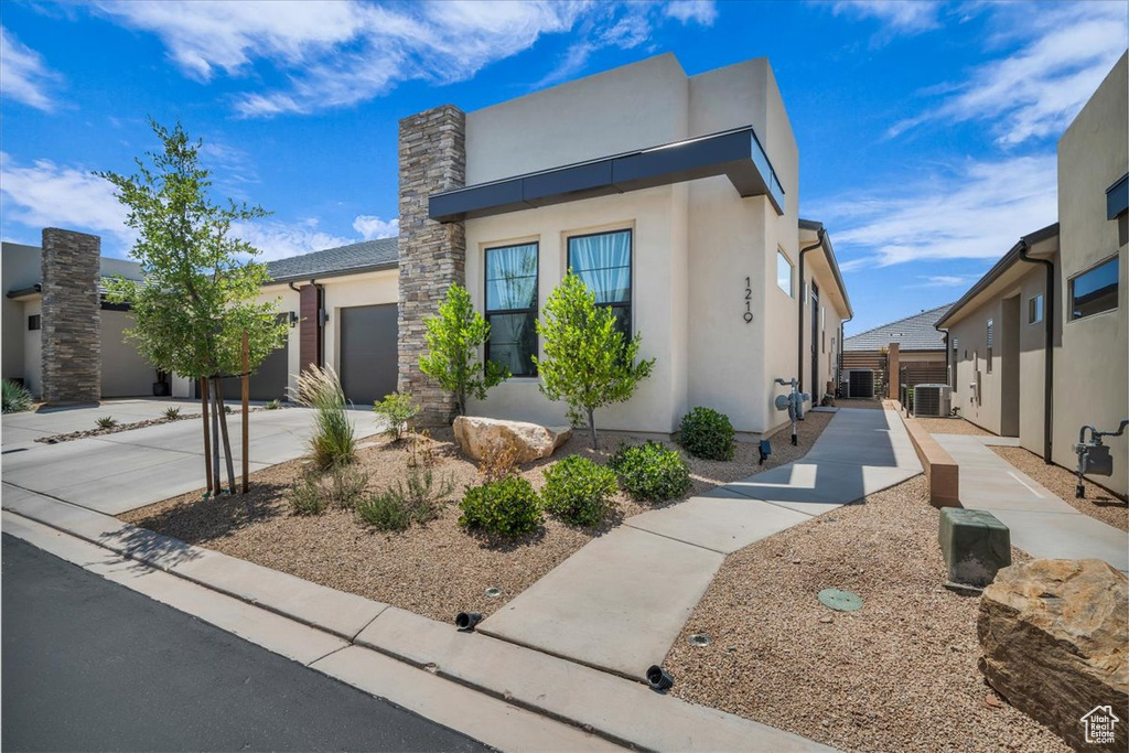Contemporary home with stucco siding, a garage, and driveway
