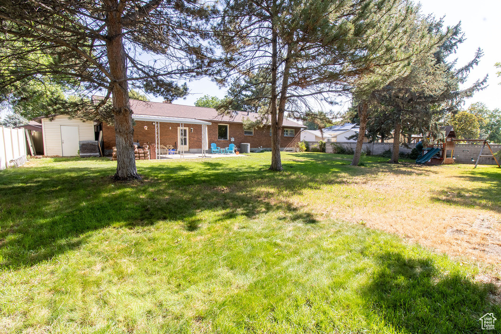 View of yard with a playground and a patio