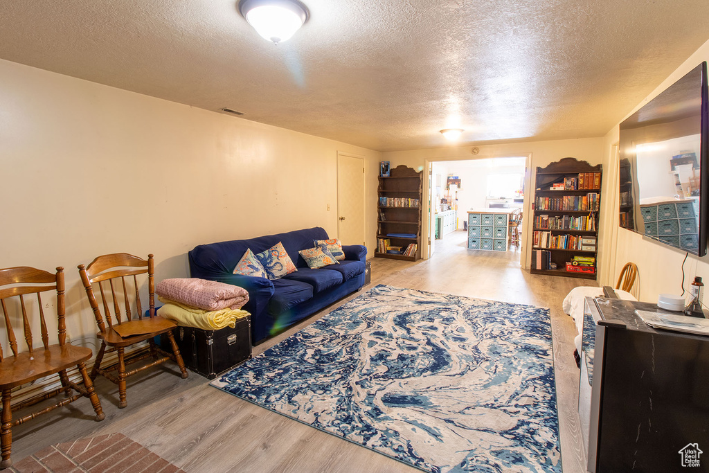 Living room with a textured ceiling and wood finished floors