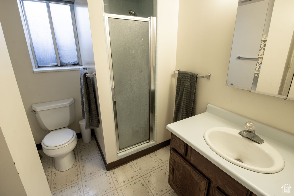 Bathroom with vanity, tile patterned floors, and a stall shower