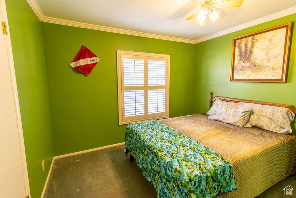 Bedroom featuring carpet flooring, ornamental molding, and a ceiling fan