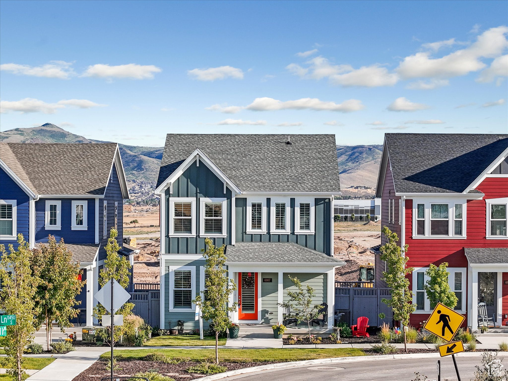 View of front of home featuring board and batten siding, a mountain view, and roof with shingles