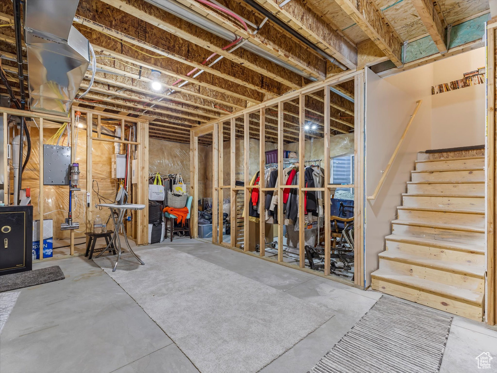 Unfinished below grade area featuring electric panel and stairs