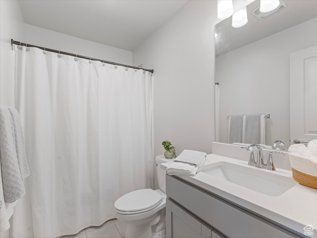 Bathroom with vanity, tile patterned floors, and a shower with shower curtain