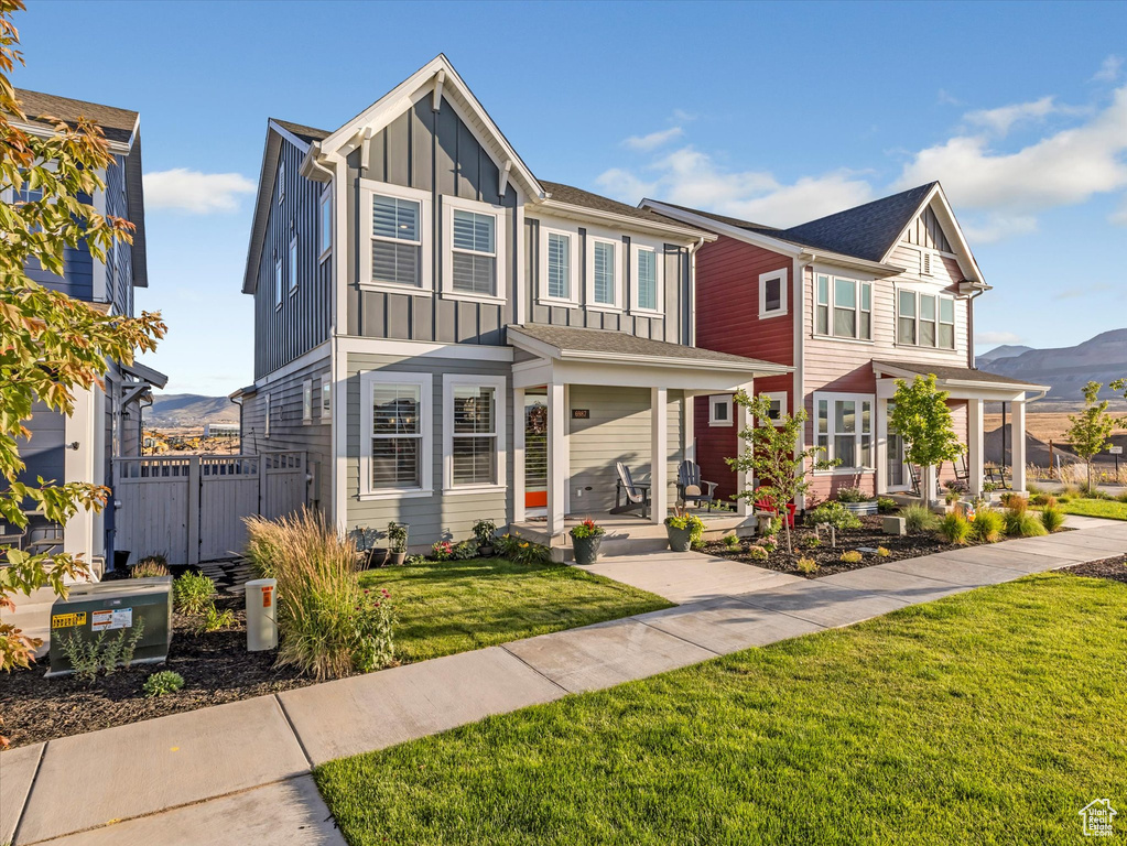 View of front of house with board and batten siding, a mountain view, and covered porch