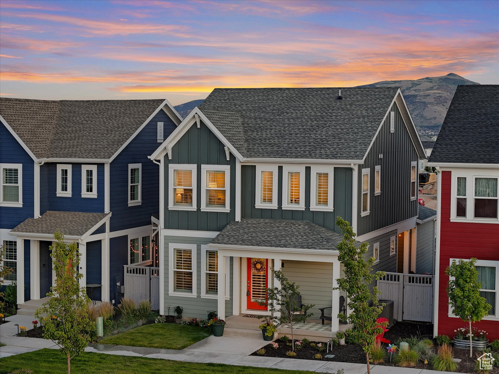 View of property featuring board and batten siding, roof with shingles, and a mountain view