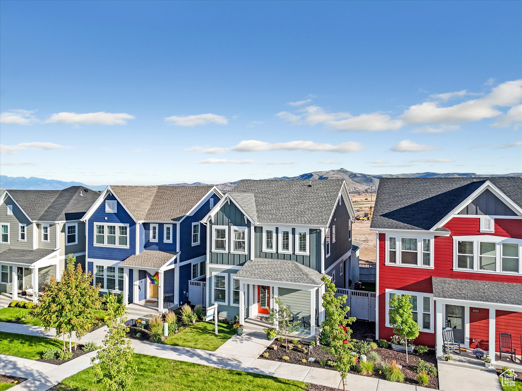 View of property featuring board and batten siding, a residential view, and a mountain view