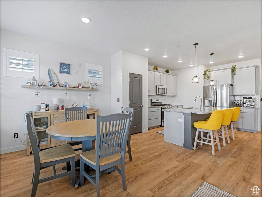 Dining room with light wood-style flooring and recessed lighting