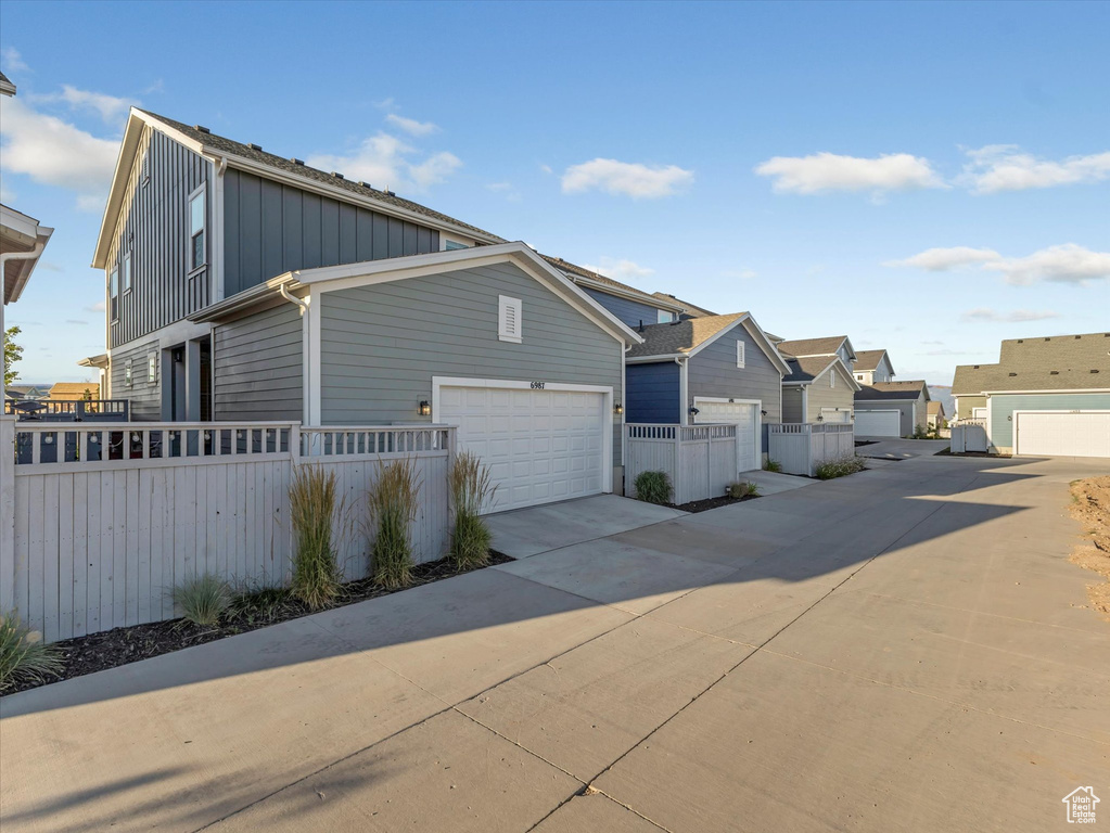 View of front of property with board and batten siding, a residential view, and driveway