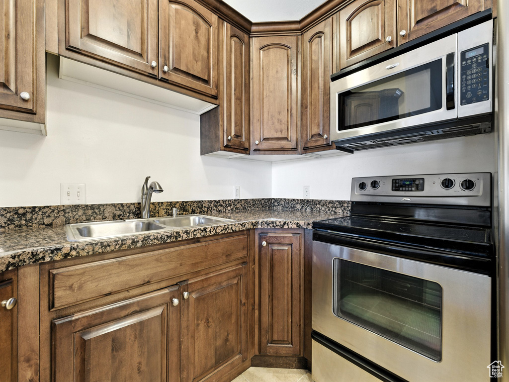 Kitchen with appliances with stainless steel finishes and dark countertops
