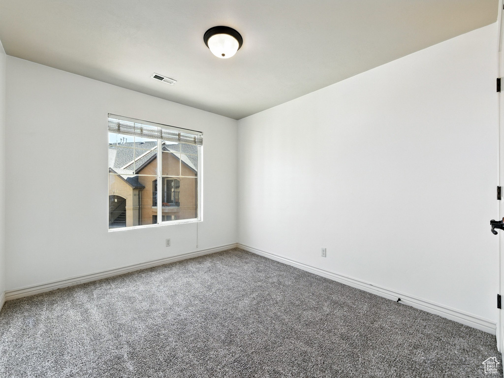 Carpeted empty room featuring baseboards