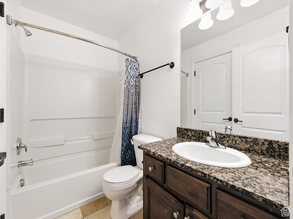 Bathroom with vanity, shower / tub combo, and tile patterned flooring