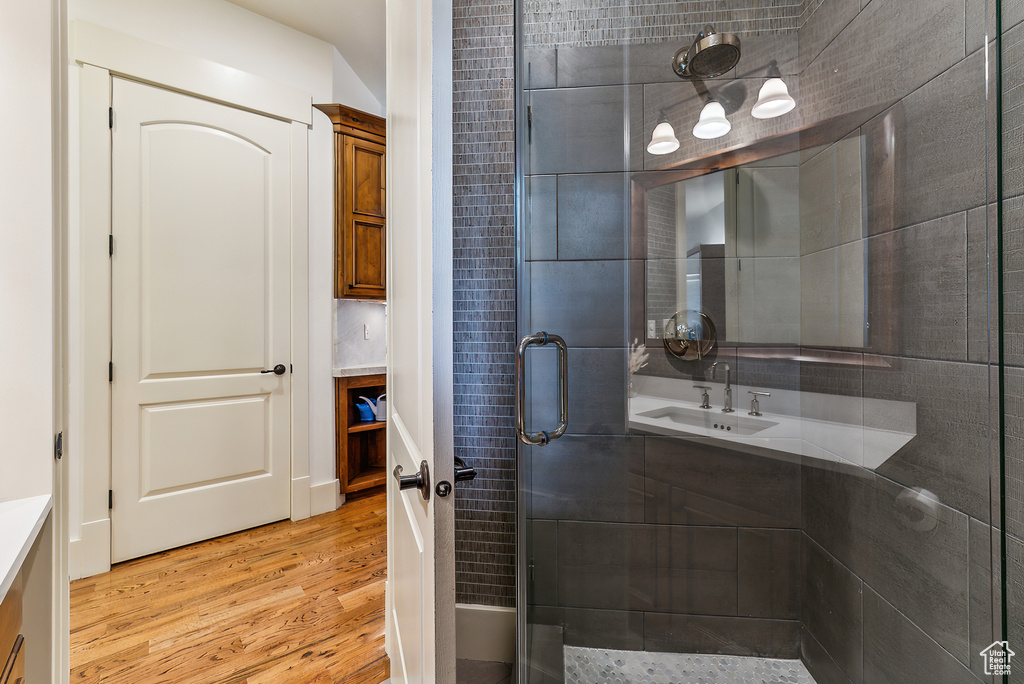 Full bath with wood finished floors, vanity, and a shower stall