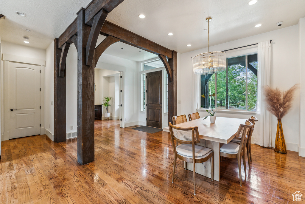 Dining area featuring recessed lighting, arched walkways, a chandelier, and wood finished floors