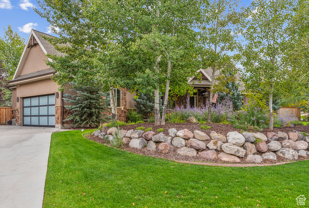 Obstructed view of property with concrete driveway, an attached garage, stucco siding, and roof with shingles
