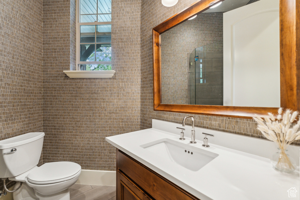 Bathroom featuring tile walls and vanity