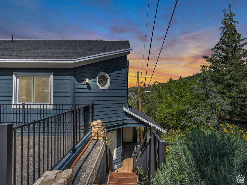 View of side of home featuring roof with shingles