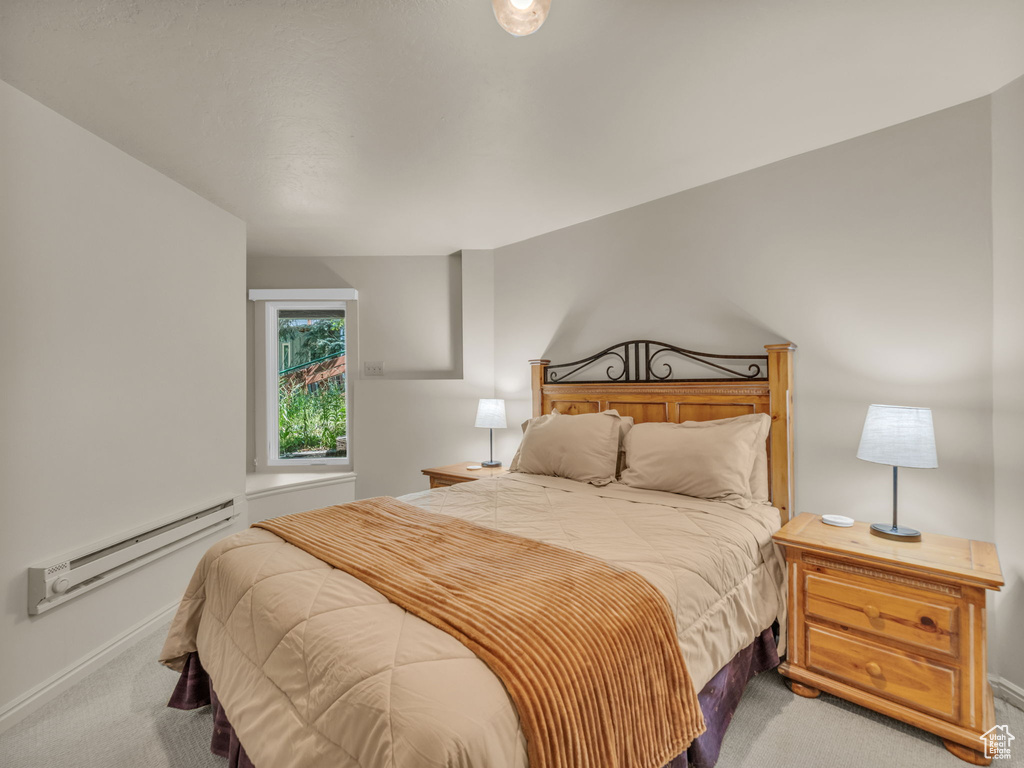 Carpeted bedroom with a baseboard radiator and baseboards