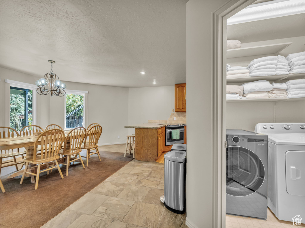 Dining space with washer and dryer, a chandelier, and recessed lighting