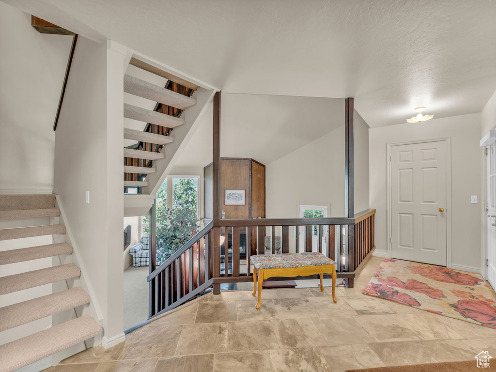 Foyer featuring stairway and stone finish floors