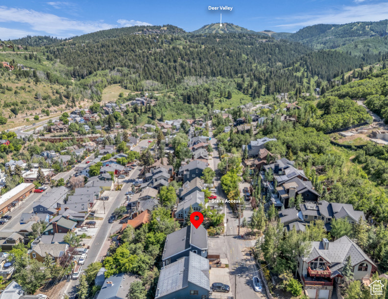 Aerial view of property and surrounding area featuring nearby suburban area