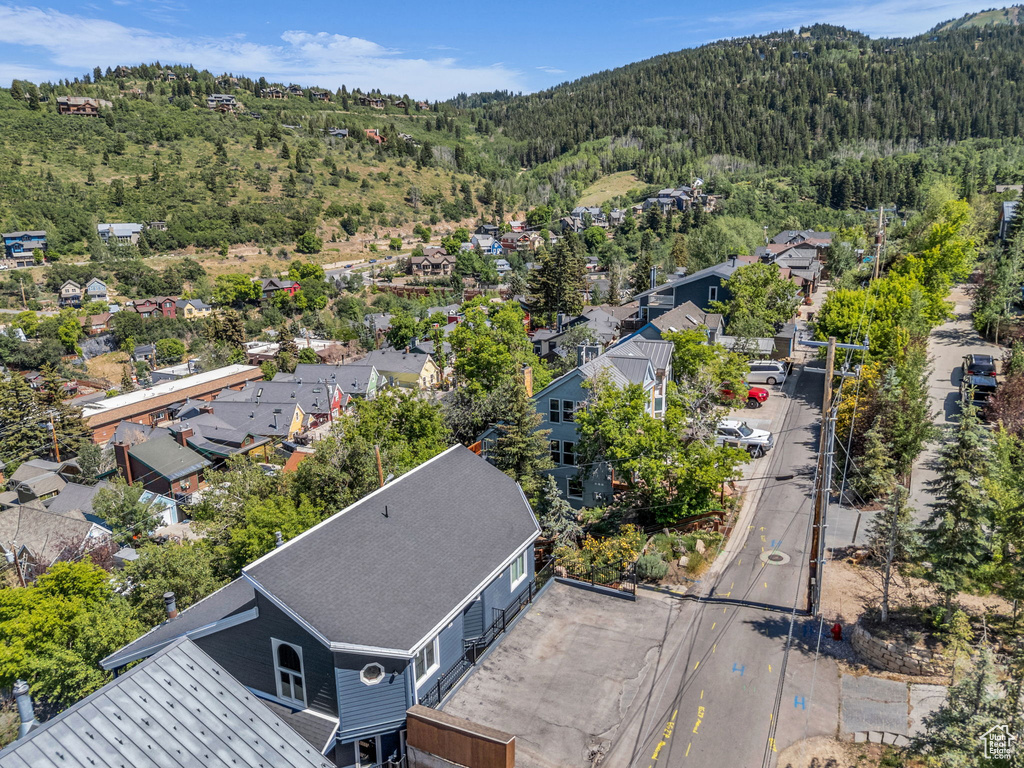 Aerial view of residential area featuring a heavily wooded area and mountains