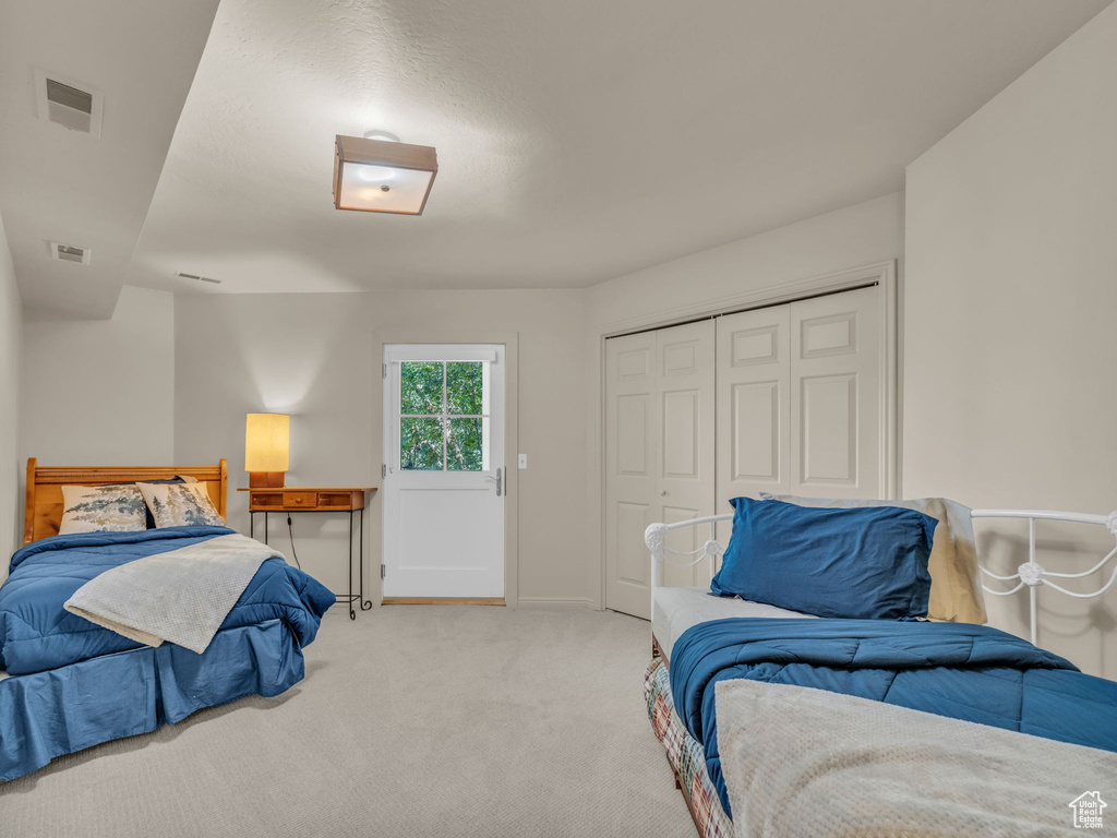 Bedroom featuring carpet and a closet