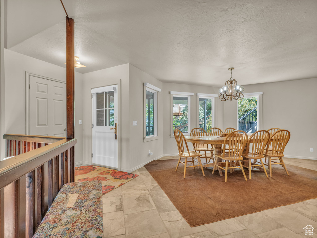 Dining area featuring a chandelier and a textured ceiling