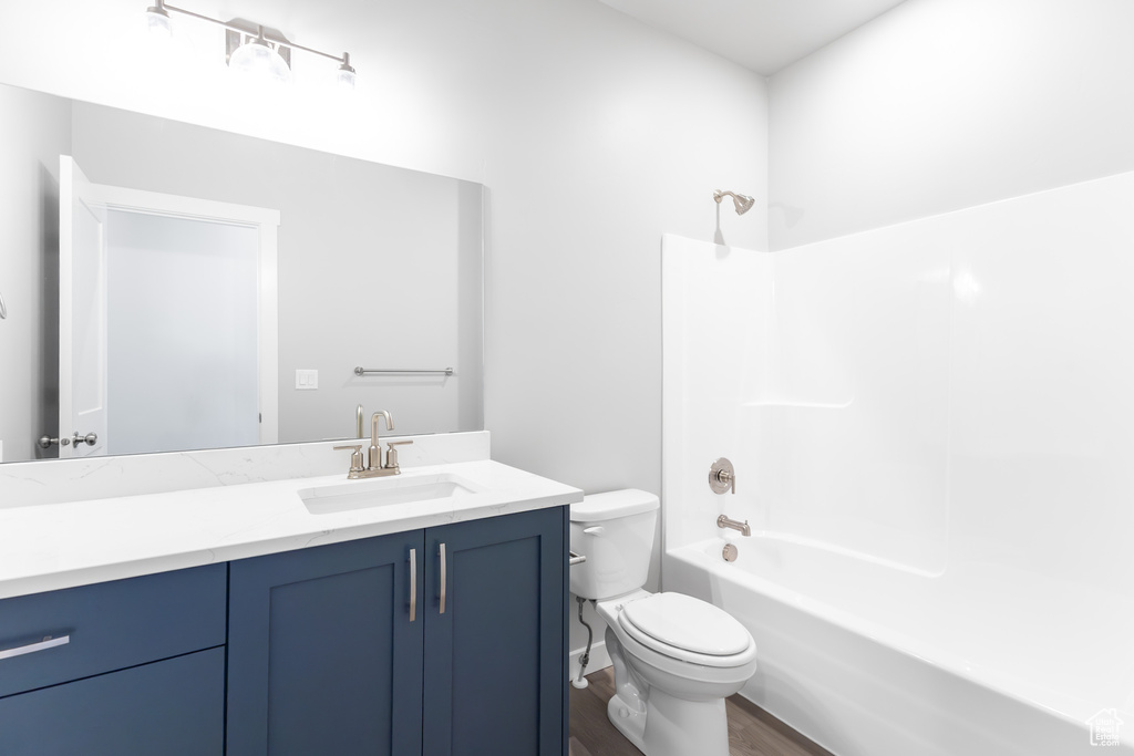 Bathroom with vanity, shower / washtub combination, and wood finished floors