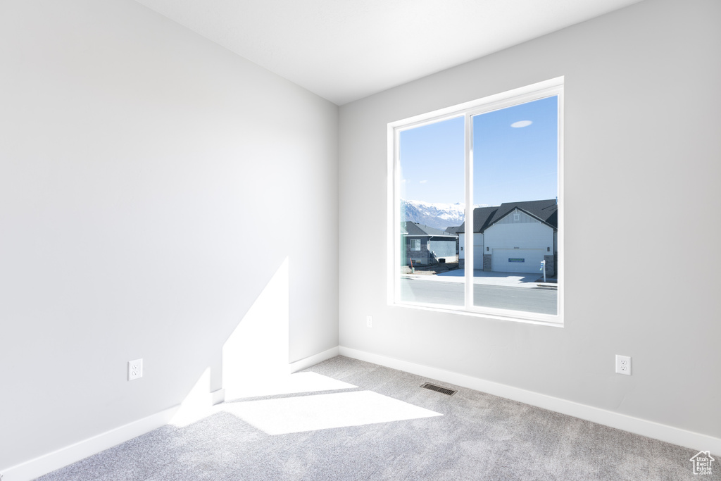 Empty room featuring carpet floors and baseboards