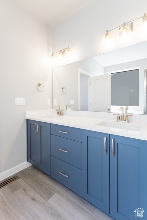 Full bath with double vanity and wood finished floors