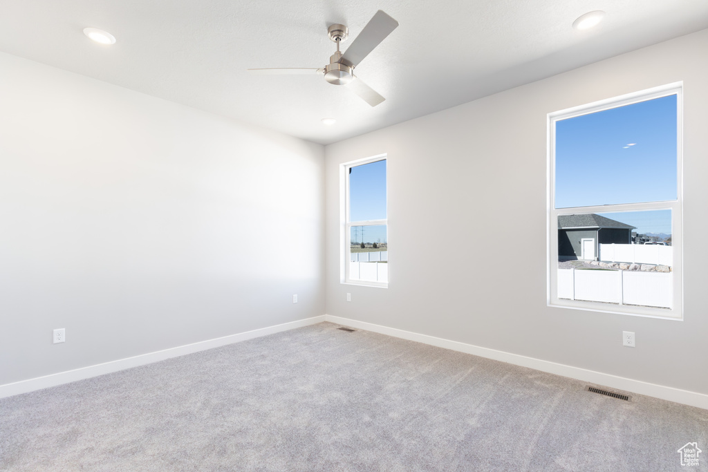 Carpeted spare room featuring a ceiling fan and recessed lighting