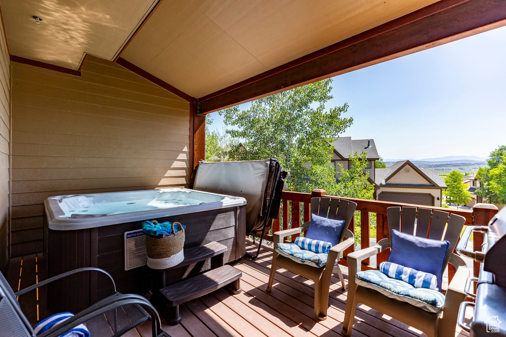 Wooden terrace featuring a hot tub and a mountain view