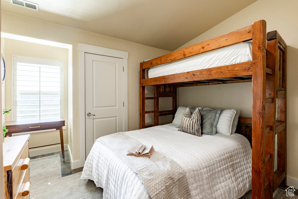 Bedroom featuring baseboards and vaulted ceiling