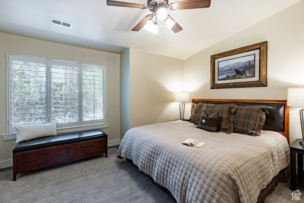 Bedroom featuring carpet, vaulted ceiling, and a ceiling fan