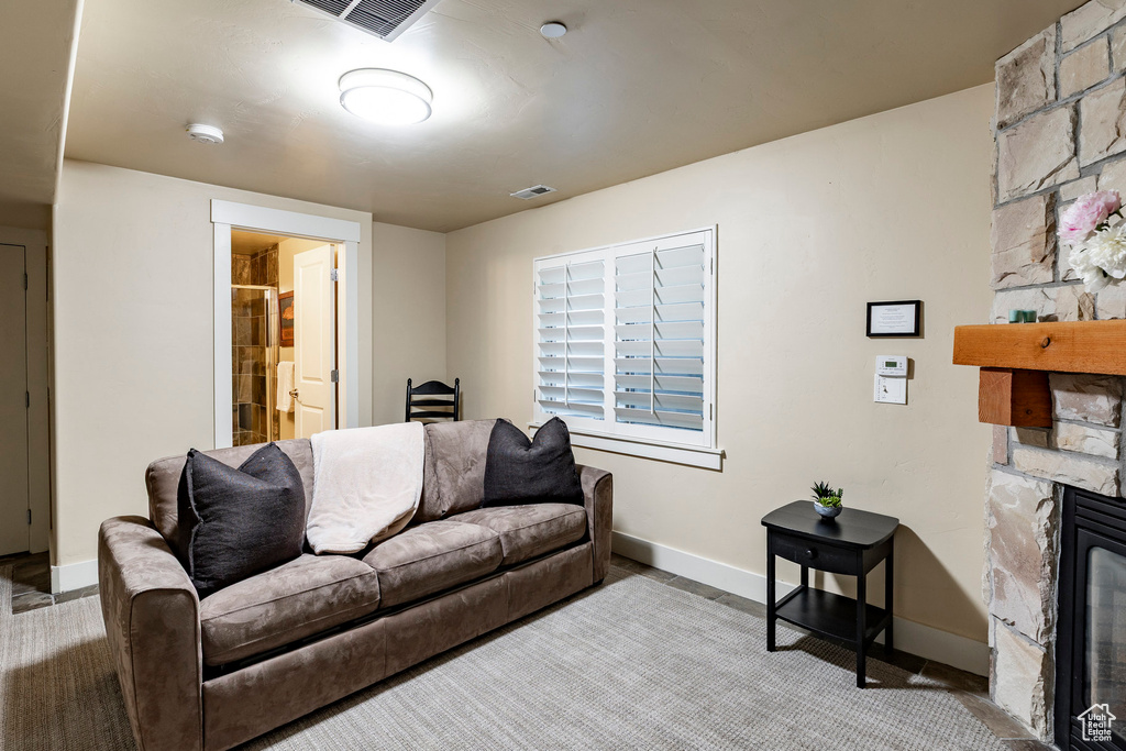 Living room featuring a stone fireplace and baseboards