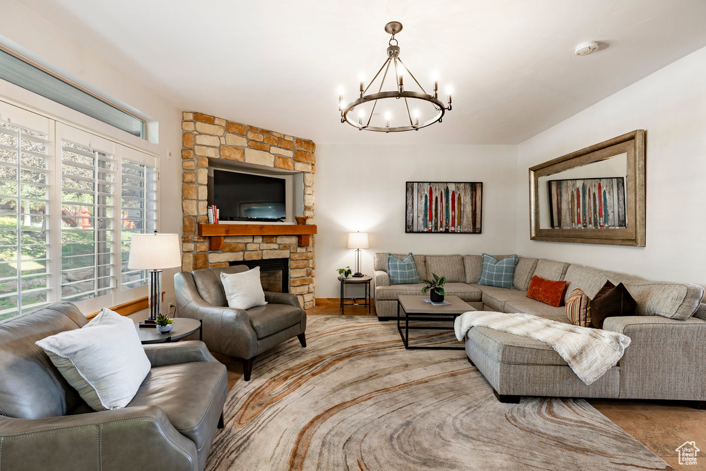 Living area featuring a chandelier and a stone fireplace