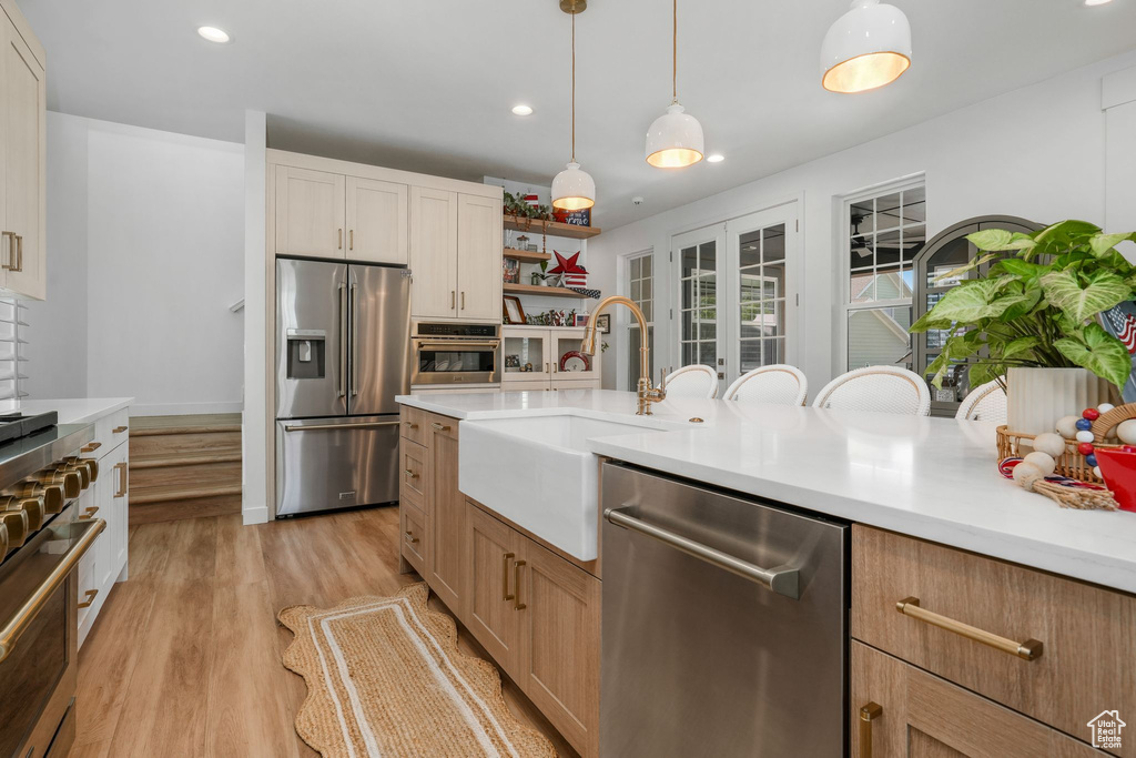 Kitchen featuring stainless steel appliances, light countertops, recessed lighting, and open shelves