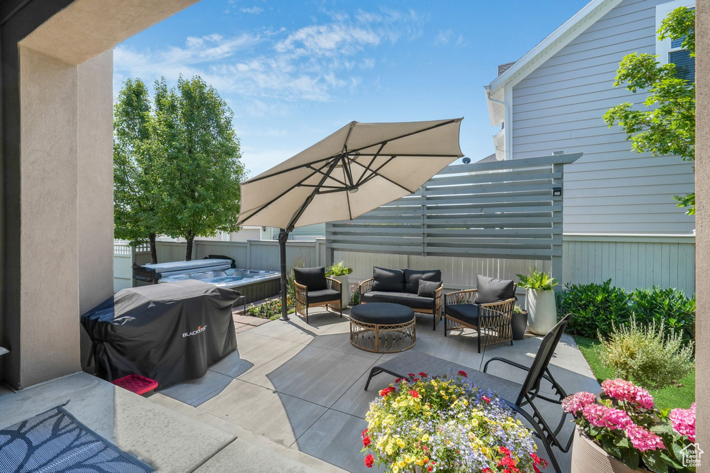 View of patio / terrace with a covered hot tub, an outdoor hangout area, and grilling area