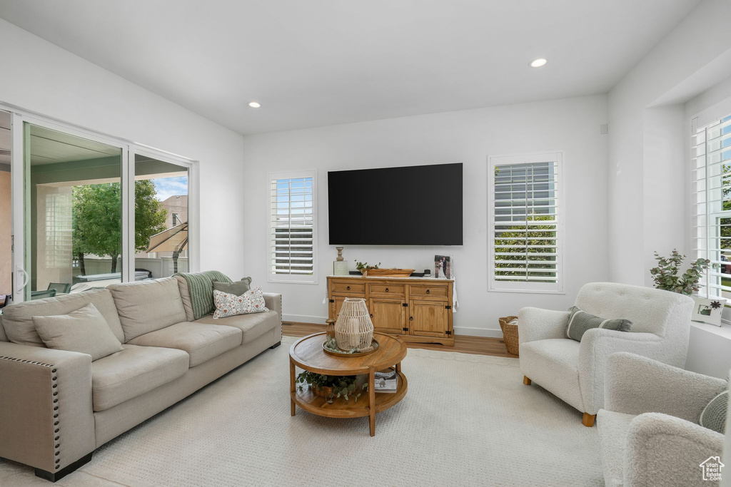 Living room with light wood-style floors and recessed lighting