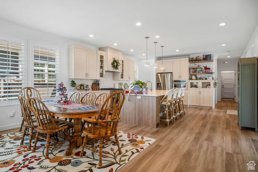 Dining room with healthy amount of natural light, light wood finished floors, and recessed lighting