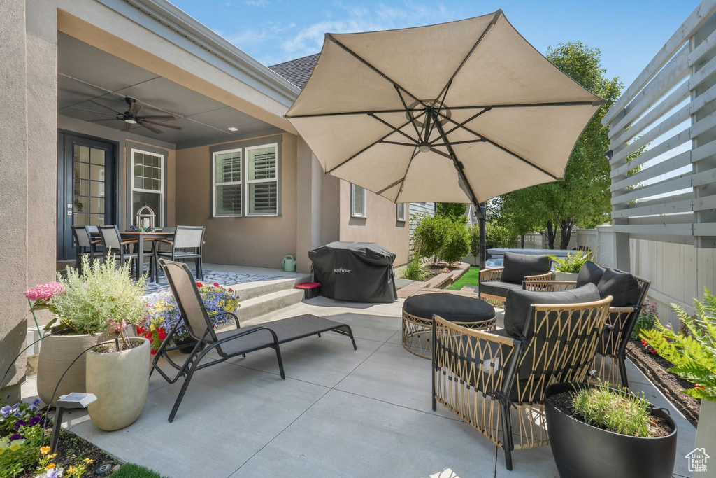 Fenced backyard with an outdoor hangout area, area for grilling, a patio area, outdoor dining area, and ceiling fan
