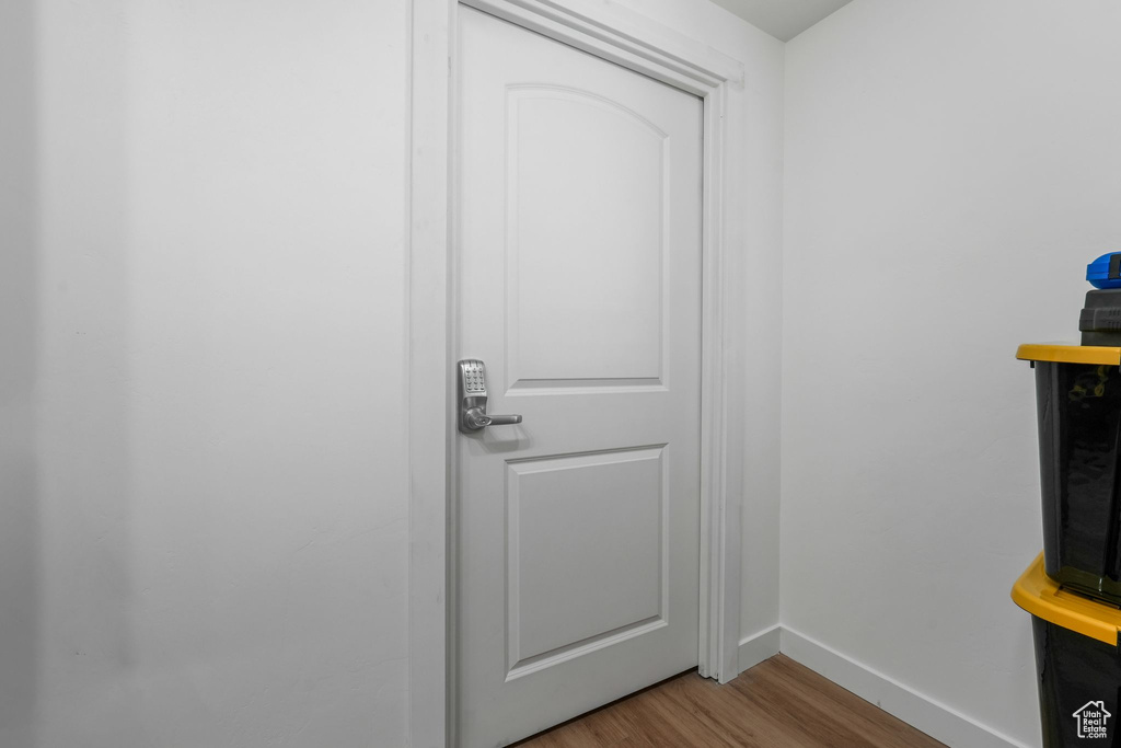 Doorway with wood finished floors and baseboards