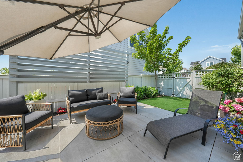 Fenced backyard with outdoor lounge area, a patio area, and a gate